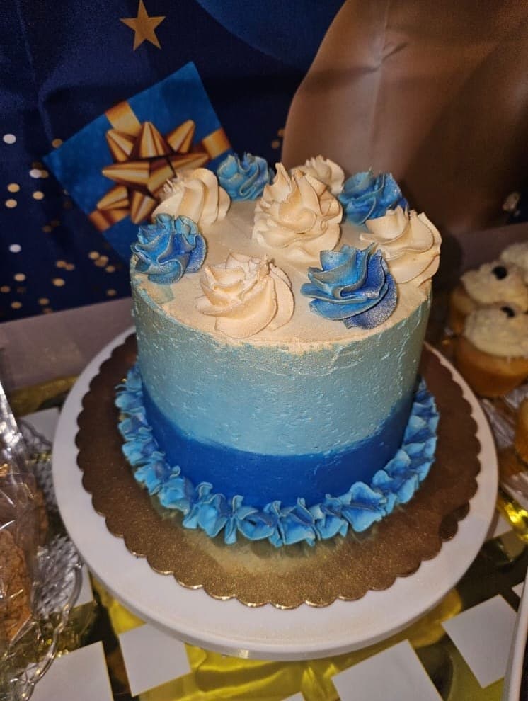 Blue ombré cake with cream and blue piped rosettes.